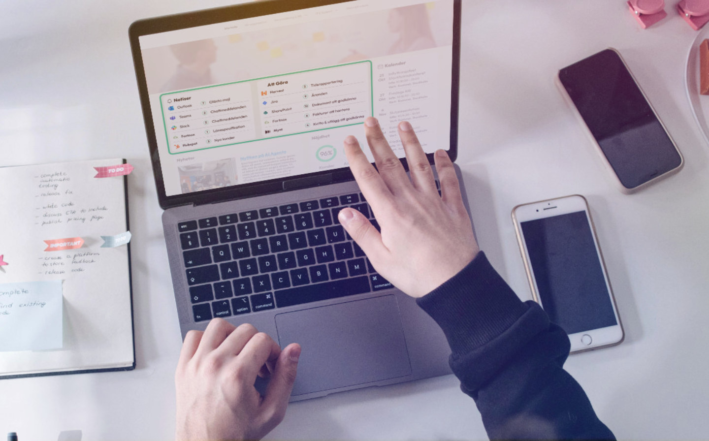 En person arbetar vid en laptop som visar en kontrollpanel med notiser och uppgifter från flera olika system.
